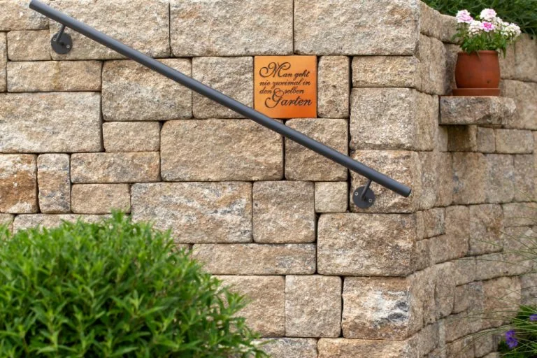 Steinmauer mit Gartenschild und Blumentopf, Garten- und Landschaftsbau, Gartengestaltung.