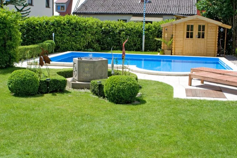 Gepflegter Garten mit Pool, Holzhaus und Gartenmöbeln perfekte Gartengestaltung.