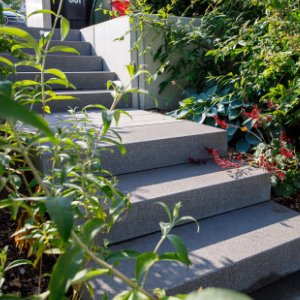 Moderne Blockstufen aus Beton als Gartentreppe mit seitlicher Bepflanzung in Weilersbach von BELLA FLORA GmbH.