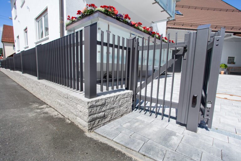 Moderner anthrazitfarbener Metallzaun mit Gartentor auf Betonsteinmauer als Zaun- und Toranlage in Forchheim von BELLA FLORA GmbH.