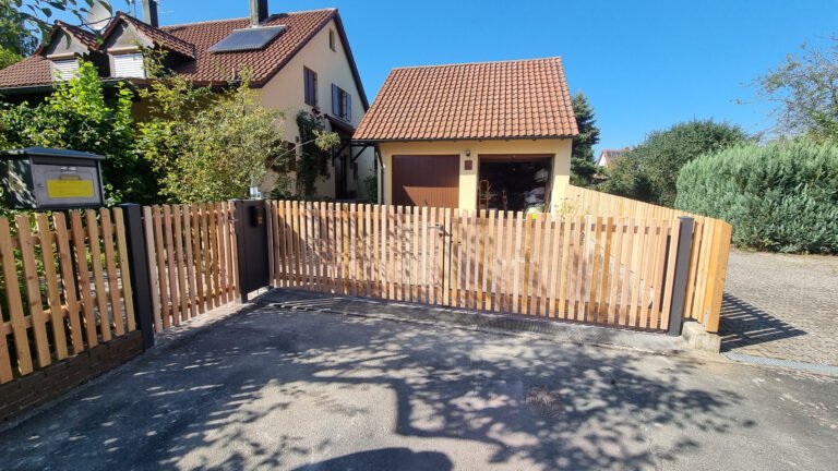 Moderner Holzlattenzaun mit Toranlage und Metallpfosten vor Einfamilienhaus, Zaunbau und Grundstückseinfassung in Fränkische Schweiz von BELLA FLORA GmbH.