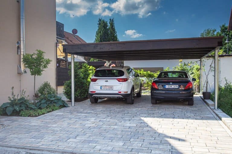 Carport mit gepflasterter Zufahrt aus Betonstein und integrierter Randbegrenzung, Einfahrt pflastern in Wiesenttal von BELLA FLORA GmbH.