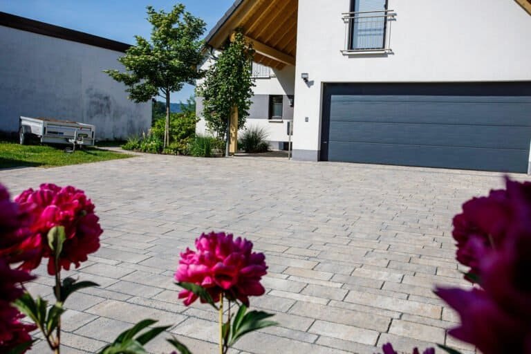 Großzügig gepflasterte Hofeinfahrt mit Betonsteinpflaster vor modernem Wohnhaus, Einfahrt pflastern in Forchheim von BELLA FLORA GmbH.