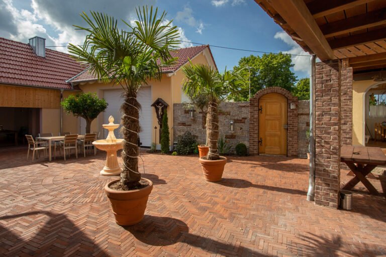 Großzügiger Innenhof mit Klinkerpflaster im Fischgrätverband, mediterrane Hofgestaltung mit Zierpflanzen in Forchheim von BELLA FLORA GmbH.