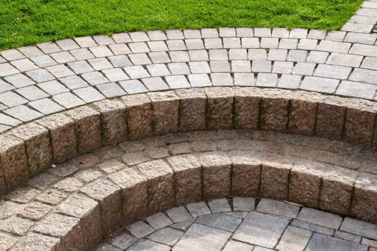 Halbrunde Trittstufen aus Naturstein mit segmentförmig verlegtem Betonpflaster im Gartenbereich, Garten- und Landschaftsbau, Wiesenttal von BELLA FLORA GmbH.