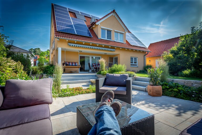 Großzügige Terrassenanlage mit Betonplatten, Granitstufen, Sitzlounge und strukturierter Staudenbepflanzung vor Einfamilienhaus, professionelle Garten- und Terrassengestaltung in Bamberg von BELLA FLORA GmbH.
