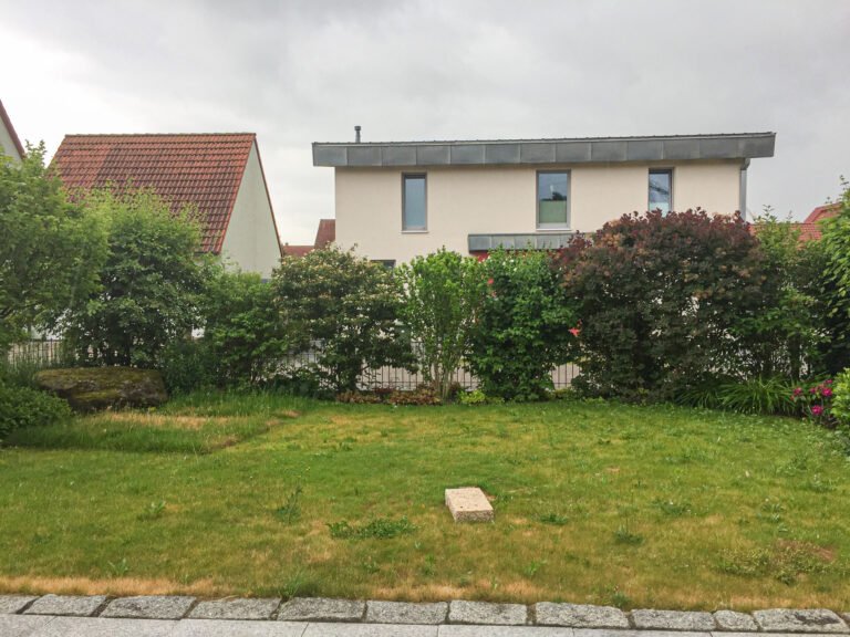 Großzügige Rasenfläche mit gewachsener Heckenbepflanzung als Gartengrundstück, Gartenumgestaltung und Gartenbau in Bamberg von BELLA FLORA GmbH.