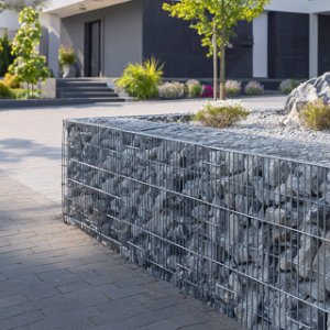 Gabionenmauer aus verzinkten Drahtkörben mit Natursteinfüllung zur Grundstücksgestaltung in Wiesenttal von BELLA FLORA GmbH.