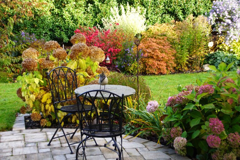 Garten-Sitzplatz mit Natursteinpflaster, Hortensien und Ziergehölzen in hochwertiger Gartengestaltung und Staudenpflanzung in Bamberg von BELLA FLORA GmbH.