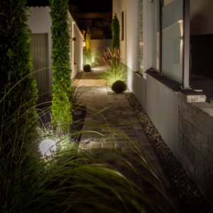 Beleuchteter Gartenweg mit moderner Bodenbeleuchtung, Pflasterarbeiten und Außenbeleuchtung in Forchheim von BELLA FLORA GmbH.