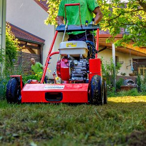 Maschinelle Rasenpflege mit Vertikutierer zur Bodenbelüftung und Rasenverbesserung, professionelle Rasenpflege in Hirschaid von BELLA FLORA GmbH.