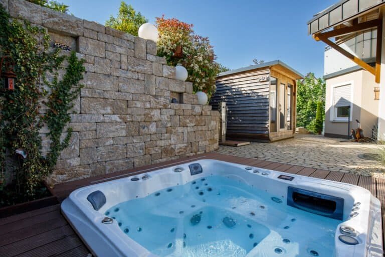 Moderner Outdoor-Whirlpool mit Betonsteinmauer und WPC-Dielenterrasse als Terrassen- und Gartenbau in Hirschaid von BELLA FLORA GmbH.