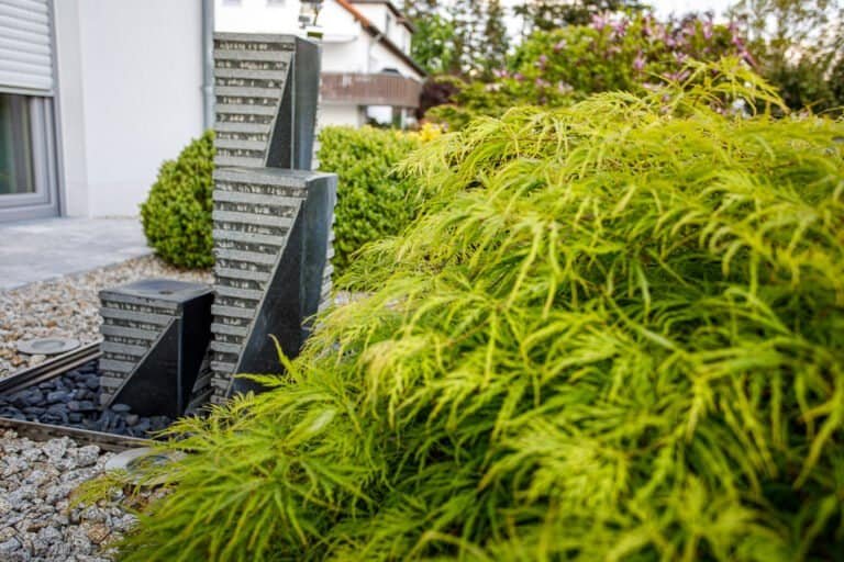 Moderner Naturstein-Brunnen mit Zierahorn und Kiesfläche als Gartengestaltung und Wasserspiel in Reuth von BELLA FLORA GmbH.
