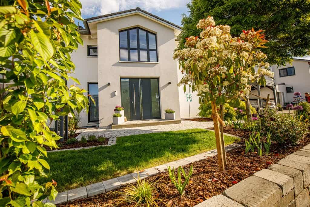 Modern gestalteter Vorgarten mit Rasenfläche, Betonsteinweg und strukturierter Bepflanzung Garten anlegen Buttenheim von BELLA FLORA GmbH.