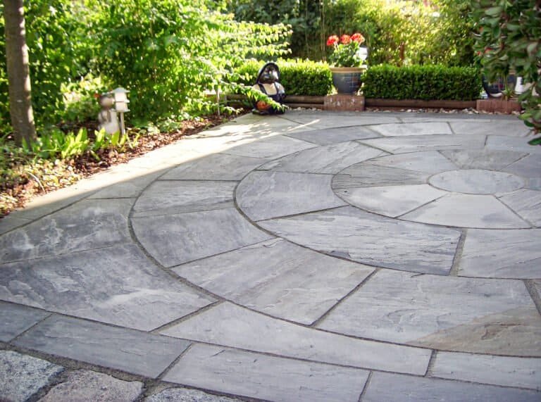 Runde Betonstein-Terrasse mit Kreisornament und großformatigen Platten im Garten – Terrassenbau in Heroldsbach von BELLA FLORA GmbH.