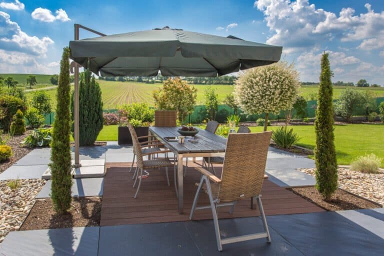 Moderne Terrasse mit Holzdeck, Feinsteinzeugplatten und klar strukturierter Gartenanlage – Terrassenbau in Heroldsbach von BELLA FLORA GmbH.